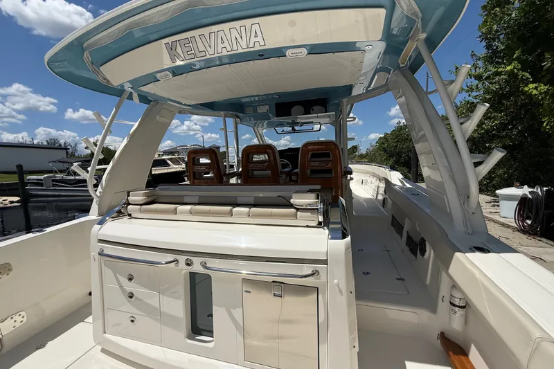 Slide: The Image of 2024 Boston Whaler 420 Outrage boat interior with seating and storage, under a clear blue sky. - 84