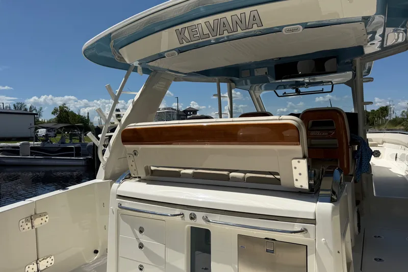 Slide: The Image of 2024 Boston Whaler 420 Outrage boat interior with seating and storage, docked under clear skies. - 43