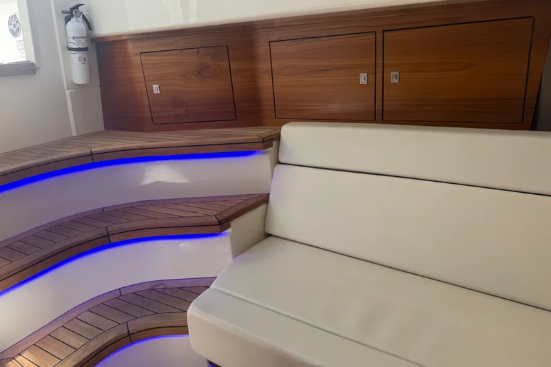 Slide: The Image of Luxurious interior of 2024 Boston Whaler 420 Outrage with LED-lit steps and cushioned seating. - 76