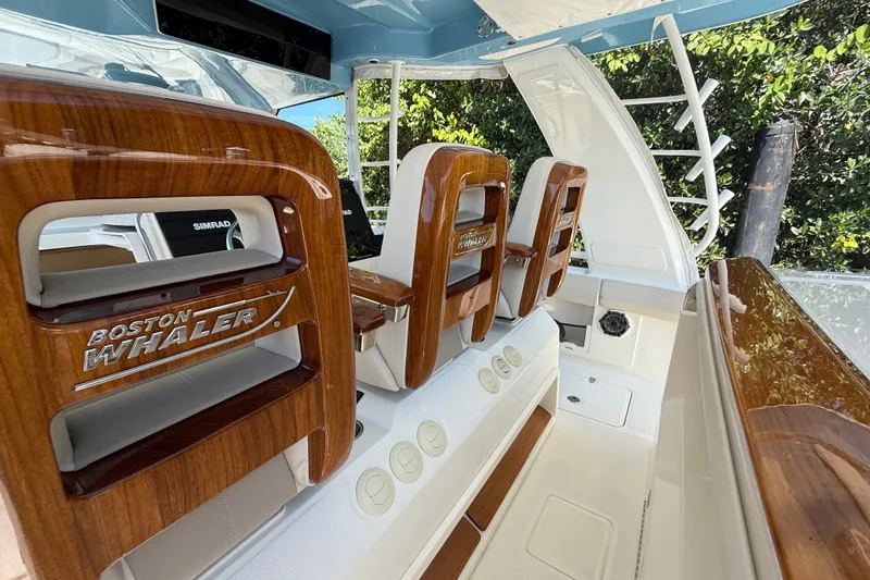 Slide: The Image of 2024 Boston Whaler 420 Outrage interior with polished wood accents and seating. - 40