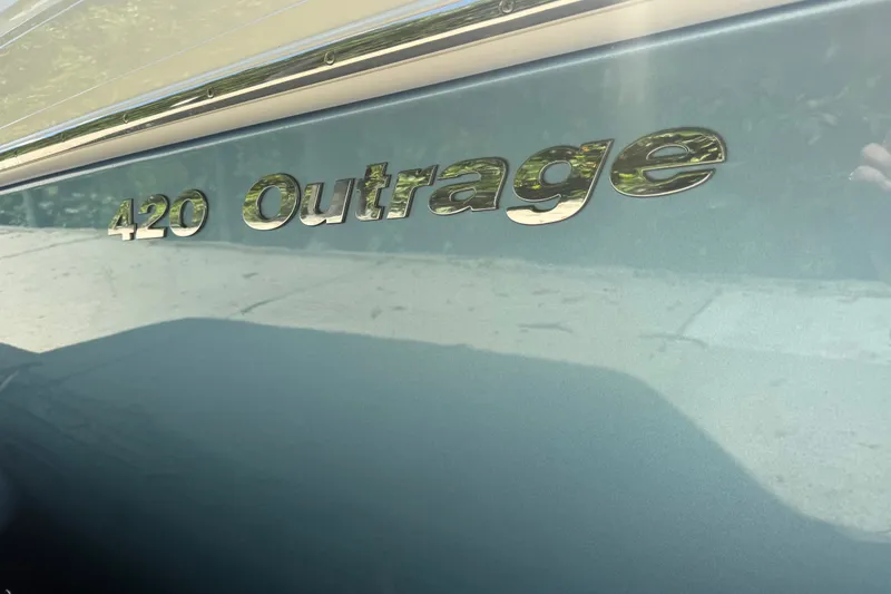 Slide: The Image of 2024 Boston Whaler 420 Outrage boat nameplate on sleek blue hull. - 47