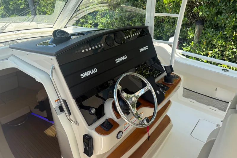 Slide: The Image of 2024 Boston Whaler 420 Outrage helm with Simrad electronics and sleek steering wheel. - 70