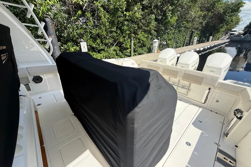 Slide: The Image of 2024 Boston Whaler 420 Outrage boat deck with covered seating and multiple engines. - 39