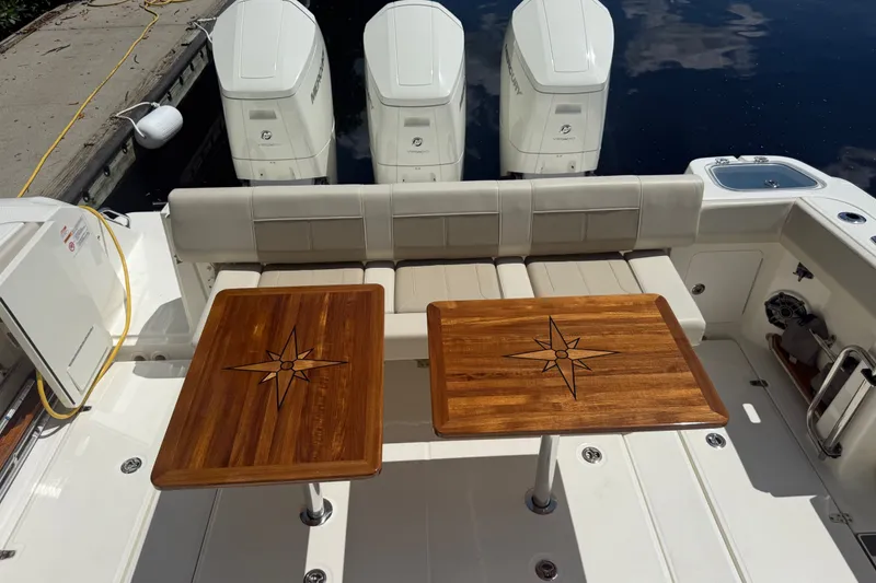 Slide: The Image of 2024 Boston Whaler 420 Outrage boat with wooden tables and triple Mercury engines. - 71
