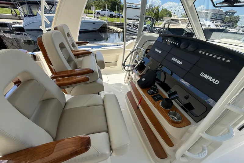 Slide: The Image of 2024 Boston Whaler 420 Outrage helm with luxurious seating and advanced Simrad navigation system. - 82