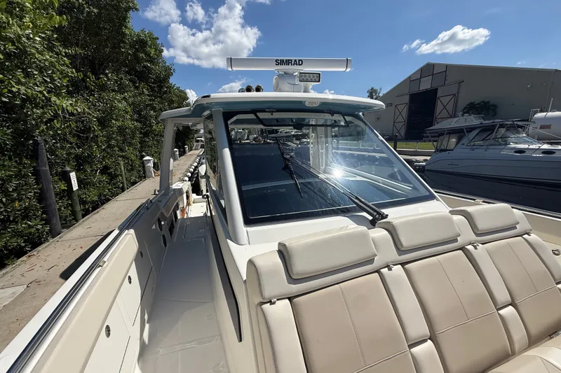 Slide: The Image of 2024 Boston Whaler 420 Outrage boat docked, featuring sleek design and advanced navigation equipment. - 9