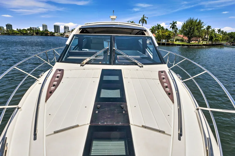 Slide: The Image of 2017 Galeon 560 Sky yacht on serene water with cityscape and palm trees. - 13