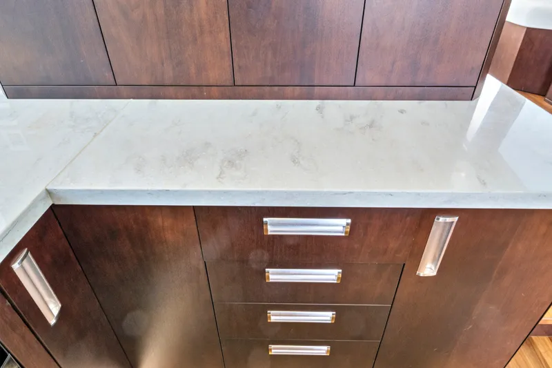 Slide: The Image of Dark wood cabinetry with sleek handles and a light marble countertop on a 2017 Galeon 560 Sky. - 21