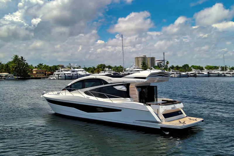Slide: The Image of 2017 Galeon 560 Sky yacht cruising on a sunny day near a marina. - 4