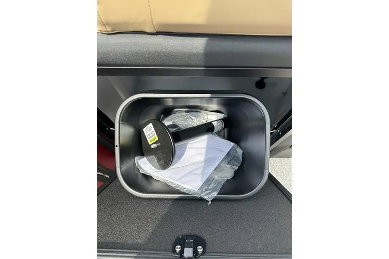 Slide: The Image of Storage compartment in Evotti 723QL 2026 model, containing a black tool and documents. - 19