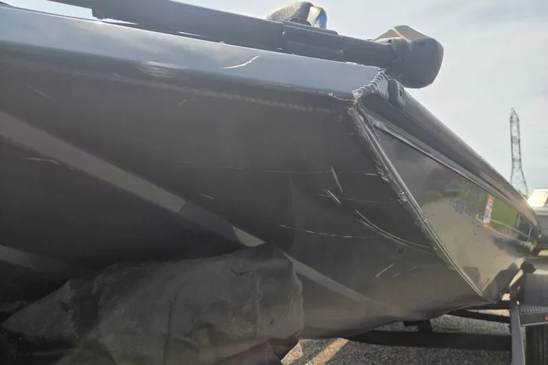 Slide: The Image of 2022 Ranger RT188 boat with visible scratches on the hull, parked on a trailer. - 9