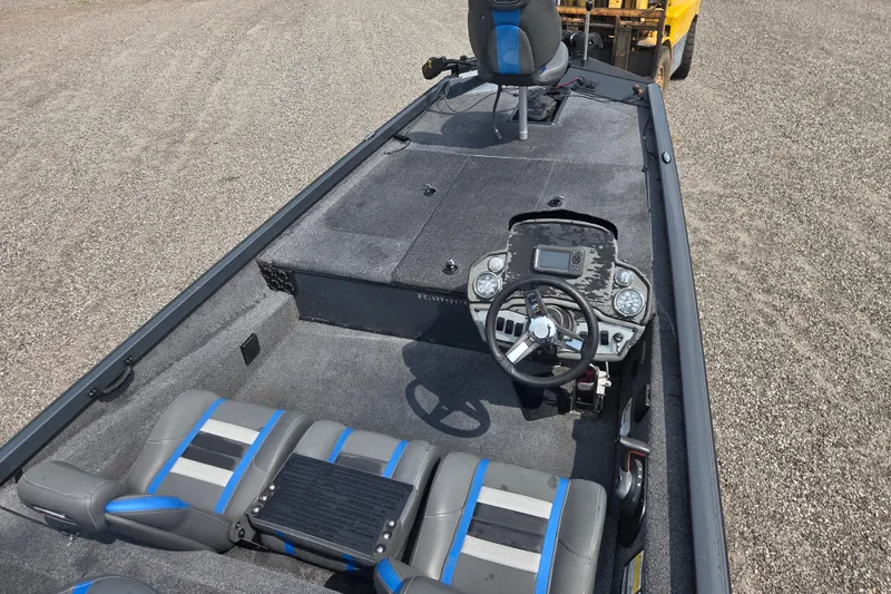 Slide: The Image of 2022 Ranger RT188 boat interior with steering console and seating, parked on gravel. - 15