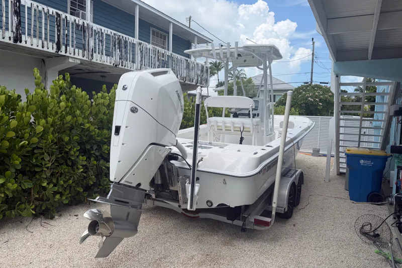 Slide: The Image of 2024 Contender 25 Bay boat with outboard motor parked in a driveway. - 29