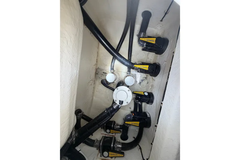 Slide: The Image of 2024 Contender 25 Bay boat plumbing system with multiple hoses and valves. - 41