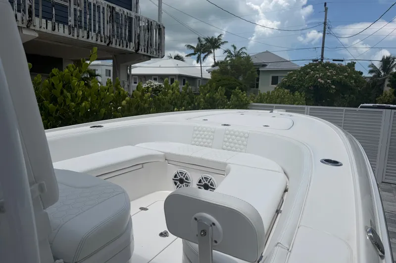 Slide: The Image of 2024 Contender 25 Bay boat with white seating and modern design in a residential setting. - 34