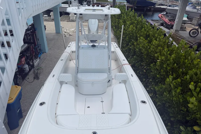 Slide: The Image of 2024 Contender 25 Bay boat docked, showcasing spacious seating and sleek design. - 31