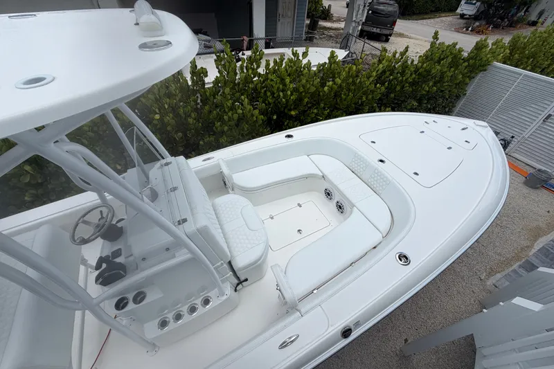 Slide: The Image of 2024 Contender 25 Bay boat with sleek white design and spacious seating area. - 32