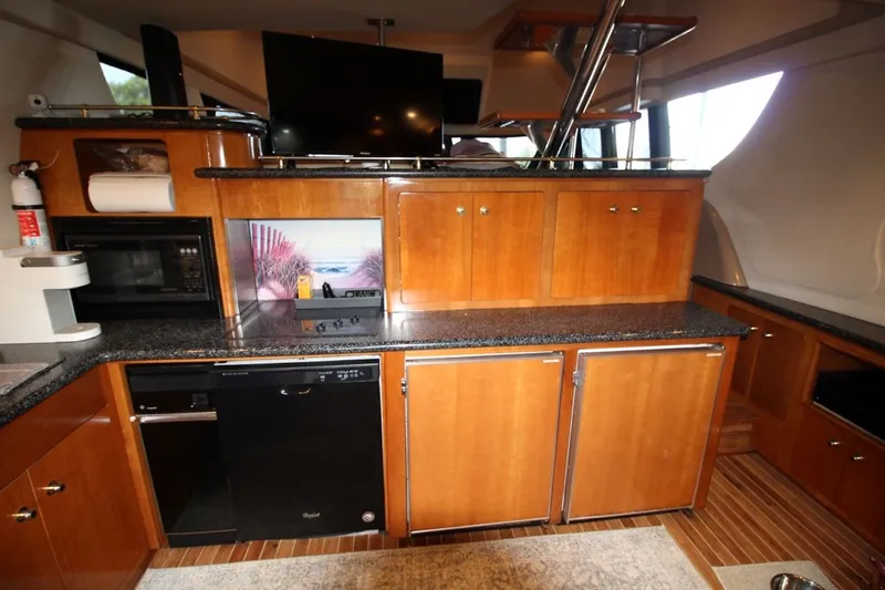 Slide: The Image of Interior of 2000 Carver 530 Voyager Pilothouse with wooden cabinetry and modern appliances. - 21