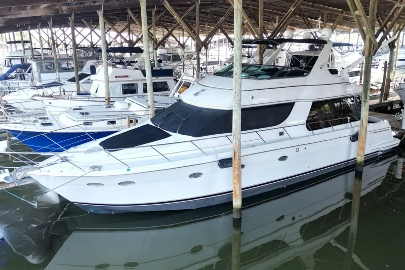 Slide: The Image of 2000 Carver 530 Voyager Pilothouse yacht docked in a marina under a wooden shelter. - 5