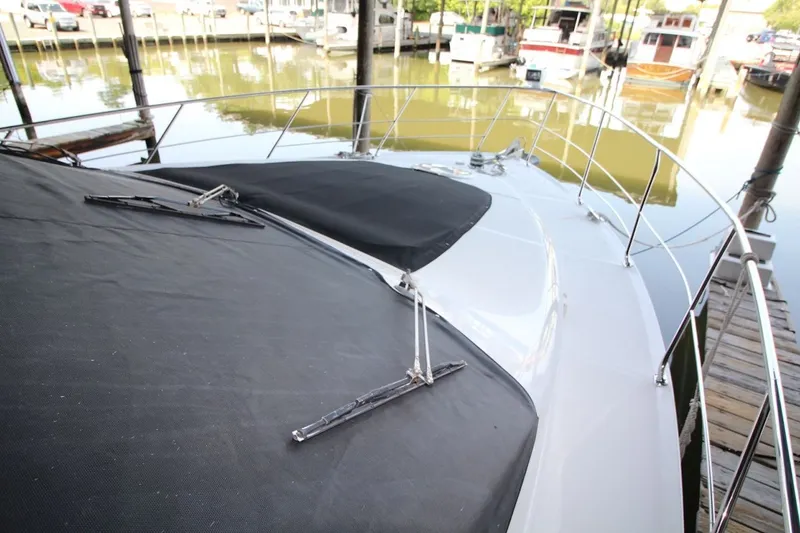 Slide: The Image of 2000 Carver 530 Voyager Pilothouse yacht docked, featuring sleek deck design and railing. - 9