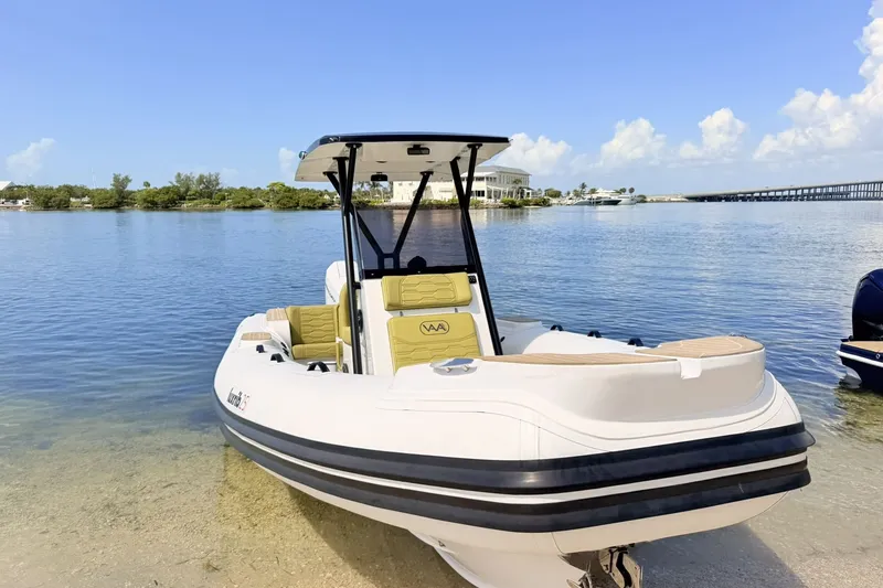 Slide: The Image of Aqvaboats Luxrib 25, 2027 model, docked on a serene waterfront. - 6