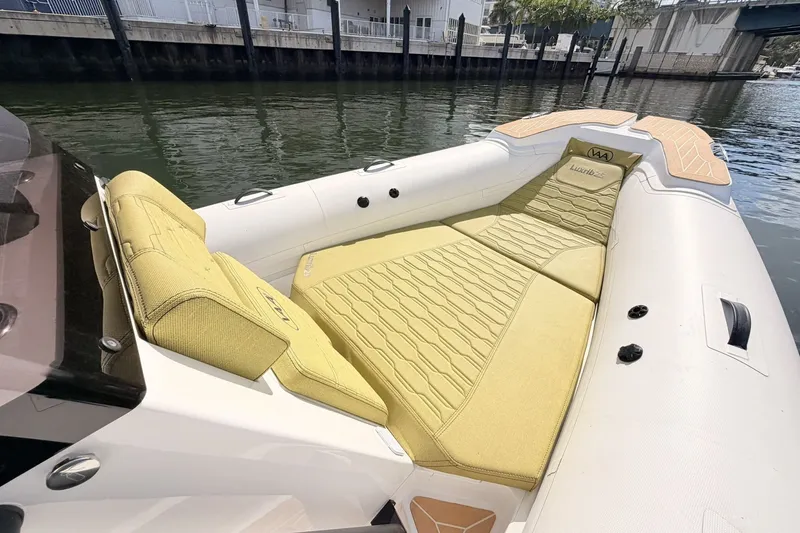Slide: The Image of Luxurious 2027 Aqvaboats Luxrib 25 with elegant seating, docked by the water. - 7