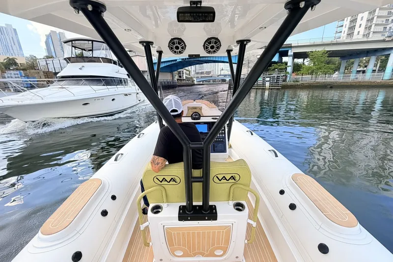 Slide: The Image of Aqvaboats Luxrib 25 navigating urban waterways, 2027 model, with cityscape and yacht in background. - 13
