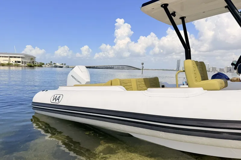 Slide: The Image of Aqvaboats Luxrib 25 (2027) moored in scenic coastal waters with bridge and buildings. - 32