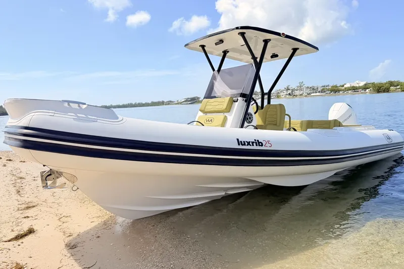 Slide: The Image of 2027 Aqvaboats Luxrib 25 on sandy shore, sleek design, calm water backdrop. - 3