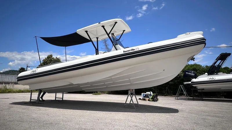Slide: The Image of Aqvaboats Luxrib 25, 2025 model, displayed outdoors under a clear blue sky. - 4