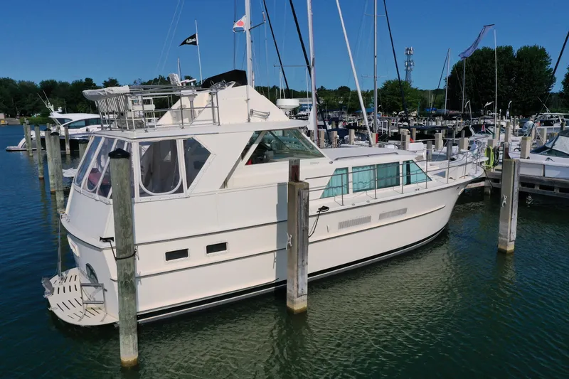 Slide: The Image of 1967 Hatteras 43 Motor Yacht docked in a marina under clear blue skies. - 2