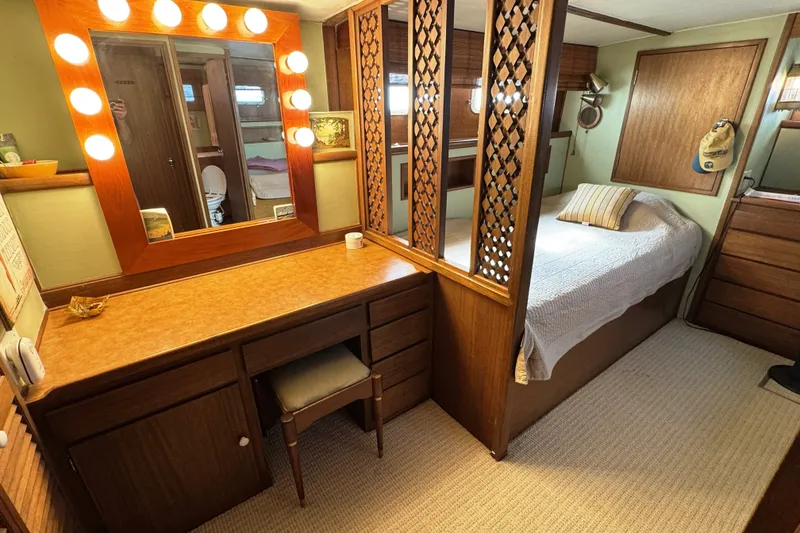 Slide: The Image of Interior of 1967 Hatteras 43 Motor Yacht with vanity, bed, and wood accents. - 26