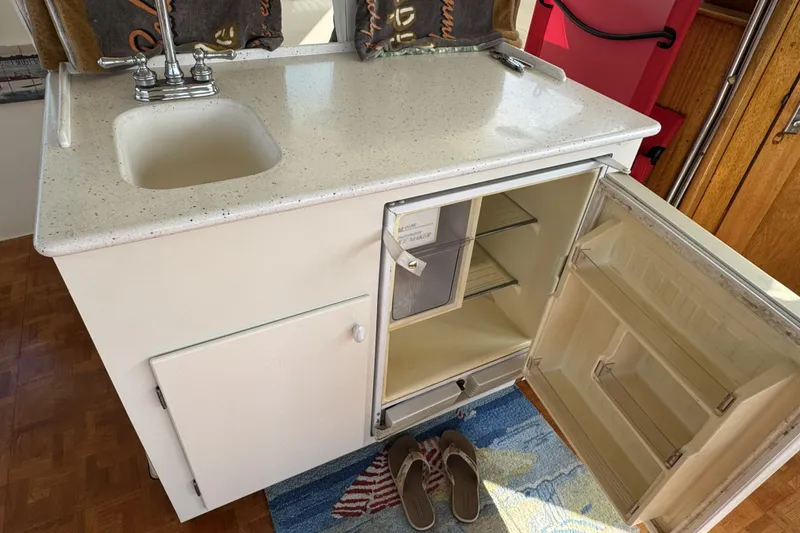 Slide: The Image of Compact kitchenette with sink and open fridge in a 1967 Hatteras 43 Motor Yacht. - 14