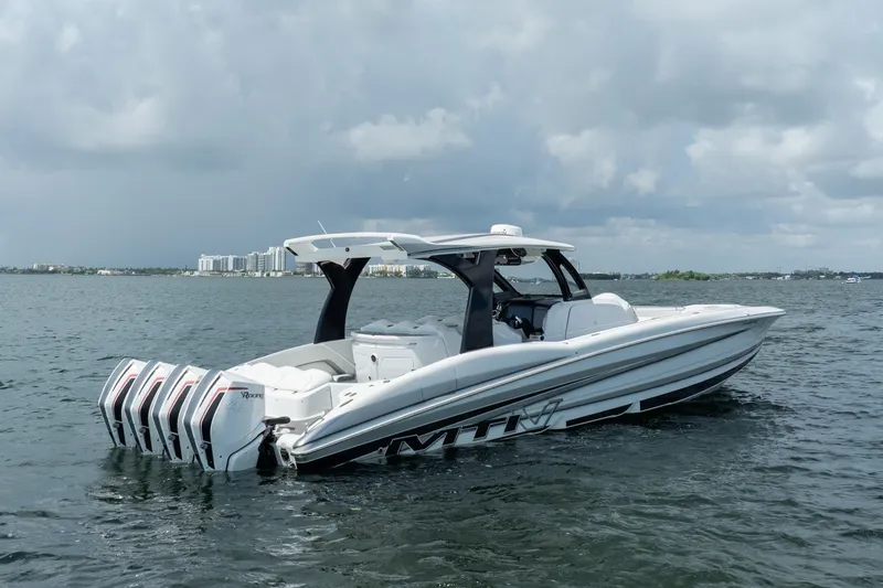 Slide: The Image of 2020 MTI V42 boat with multiple engines on a calm sea under cloudy skies. - 2