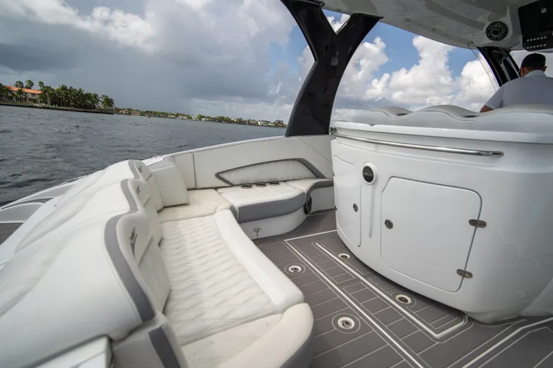 Slide: The Image of Luxurious MTI V42 boat interior with white seating, cruising on a scenic waterway. - 12