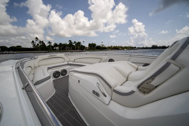 Slide: The Image of Luxurious 2020 MTI V42 boat interior with plush seating, set against a scenic waterfront backdrop. - 9