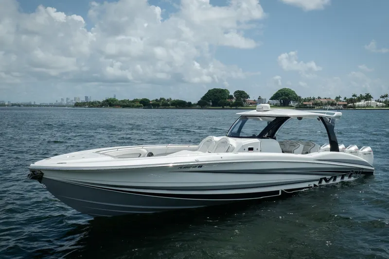 Slide: The Image of 2020 MTI V42 boat cruising on a sunny day with city skyline in the background. - 17