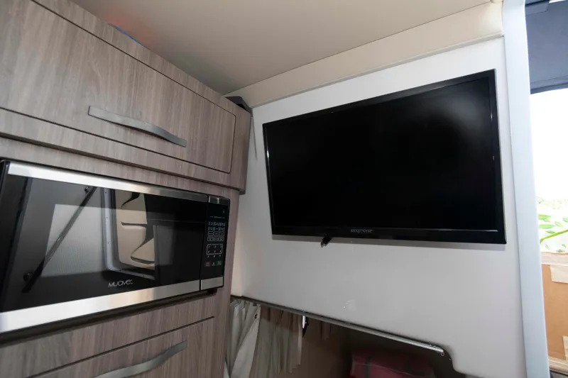 Slide: The Image of 2020 Regal 2860 Window Express interior with microwave and mounted TV. - 15