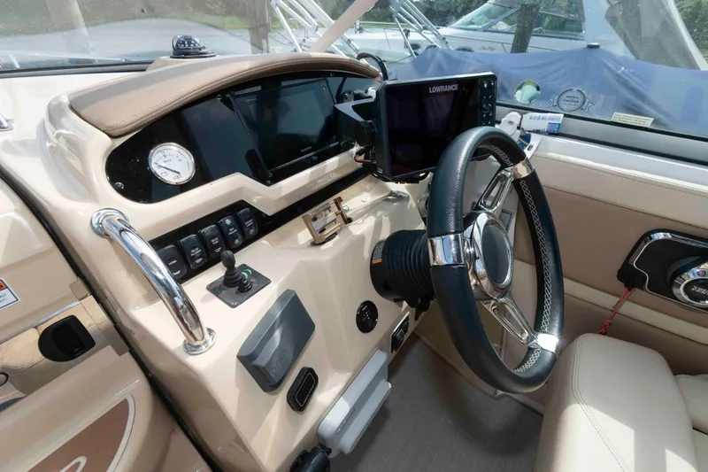 Slide: The Image of 2020 Regal 2860 Window Express boat dashboard with steering wheel and navigation controls. - 8