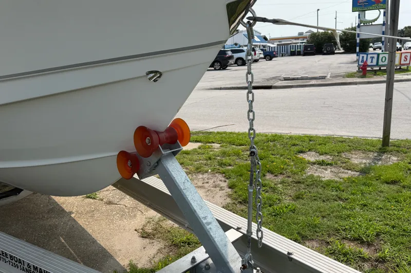 Slide: The Image of 2024 Sea Hunt Ultra 275 SE boat on trailer, secured with chain and rollers. - 16