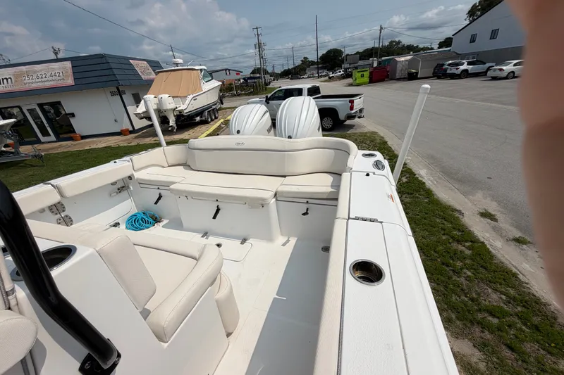 Slide: The Image of 2024 Sea Hunt Ultra 275 SE boat interior with seating and storage, parked outdoors. - 49