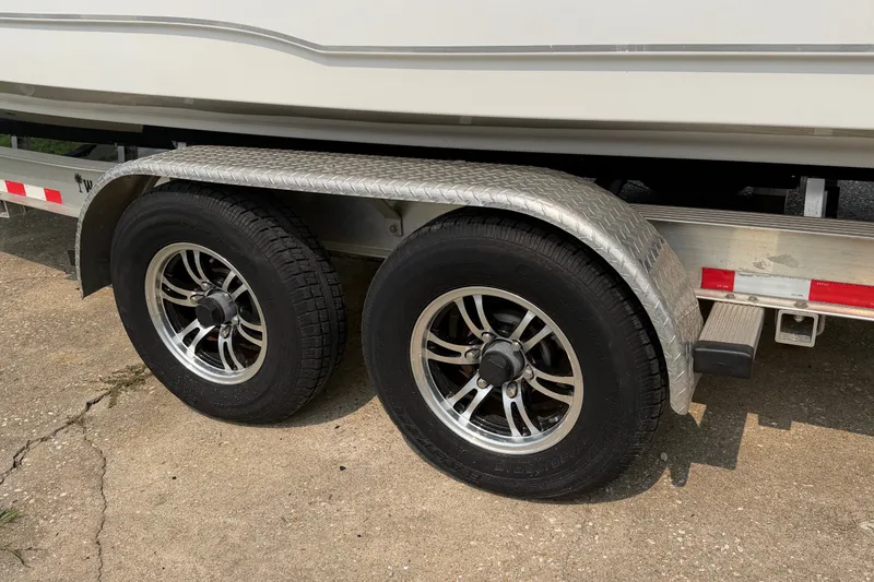 Slide: The Image of 2024 Sea Hunt Ultra 275 SE trailer with dual wheels on concrete surface. - 3