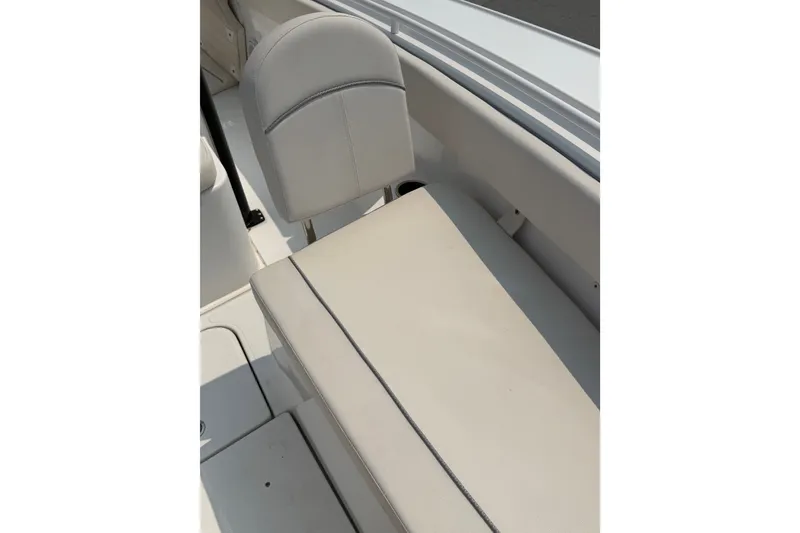 Slide: The Image of 2024 Sea Hunt Ultra 275 SE boat interior seating, featuring sleek white upholstery. - 30