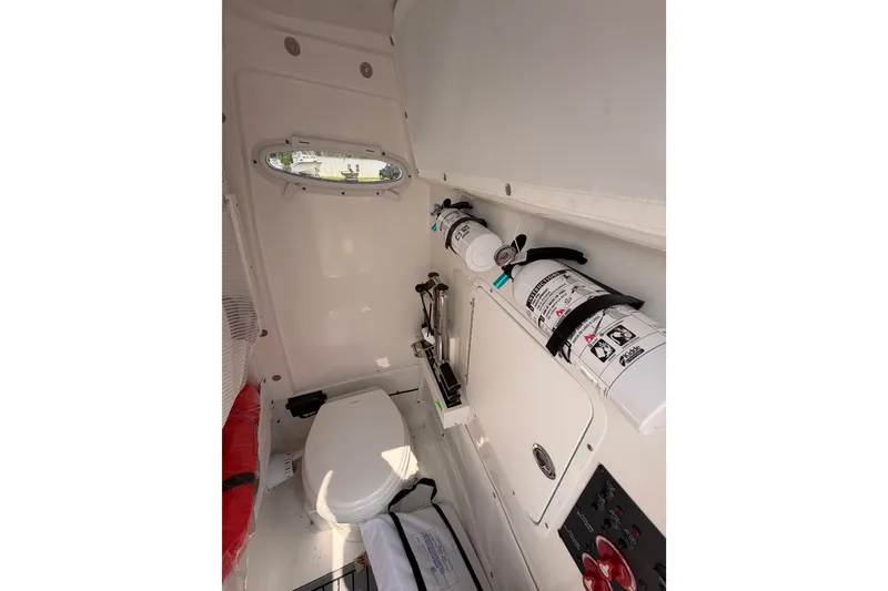 Slide: The Image of Interior of 2024 Sea Hunt Ultra 275 SE boat with toilet and safety equipment. - 53