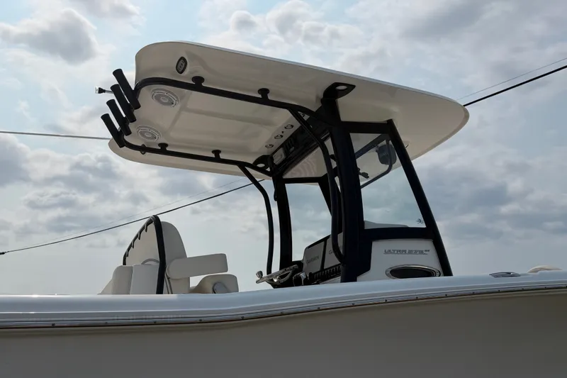 Slide: The Image of 2024 Sea Hunt Ultra 275 SE boat with T-top and console, under cloudy sky. - 12