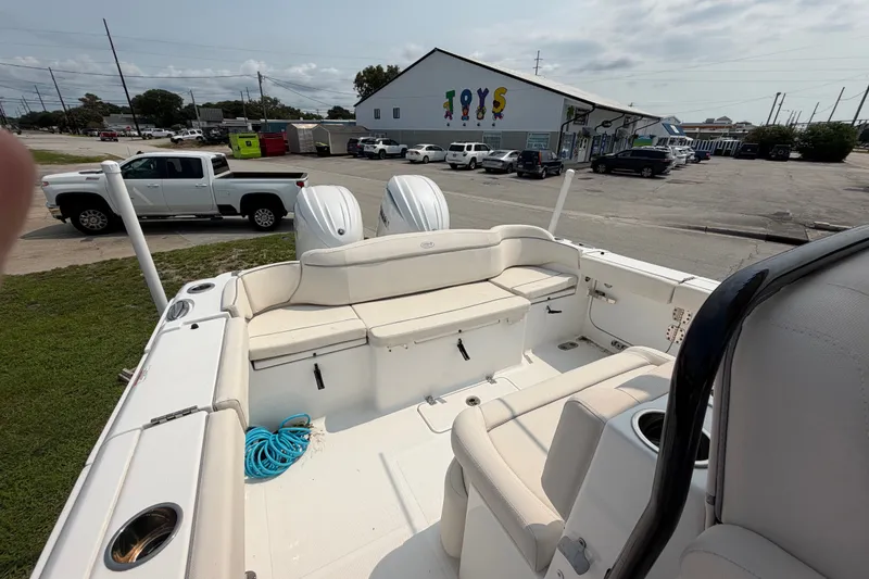 Slide: The Image of 2024 Sea Hunt Ultra 275 SE boat with dual engines, parked near a toy store. - 50