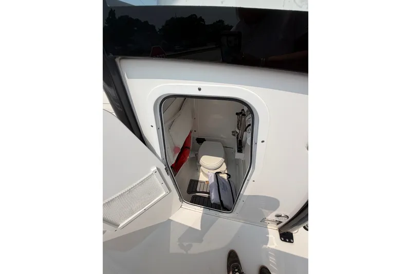 Slide: The Image of 2024 Sea Hunt Ultra 275 SE boat interior with compact restroom and storage. - 52
