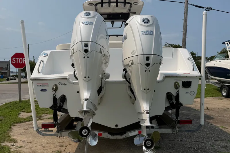 Slide: The Image of 2024 Sea Hunt Ultra 275 SE boat with dual Yamaha 200 engines, parked outdoors. - 7