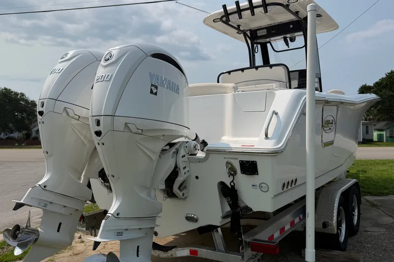 Slide: The Image of 2024 Sea Hunt Ultra 275 SE boat with dual Yamaha 200 engines on a trailer. - 10