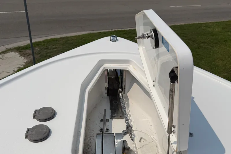Slide: The Image of 2024 Sea Hunt Ultra 275 SE anchor compartment with open hatch, showcasing chain and mechanism. - 27
